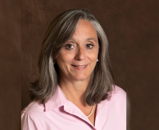 Patricia “Patty” Montone Charvat 'in a pink shirt smiles at the camera.